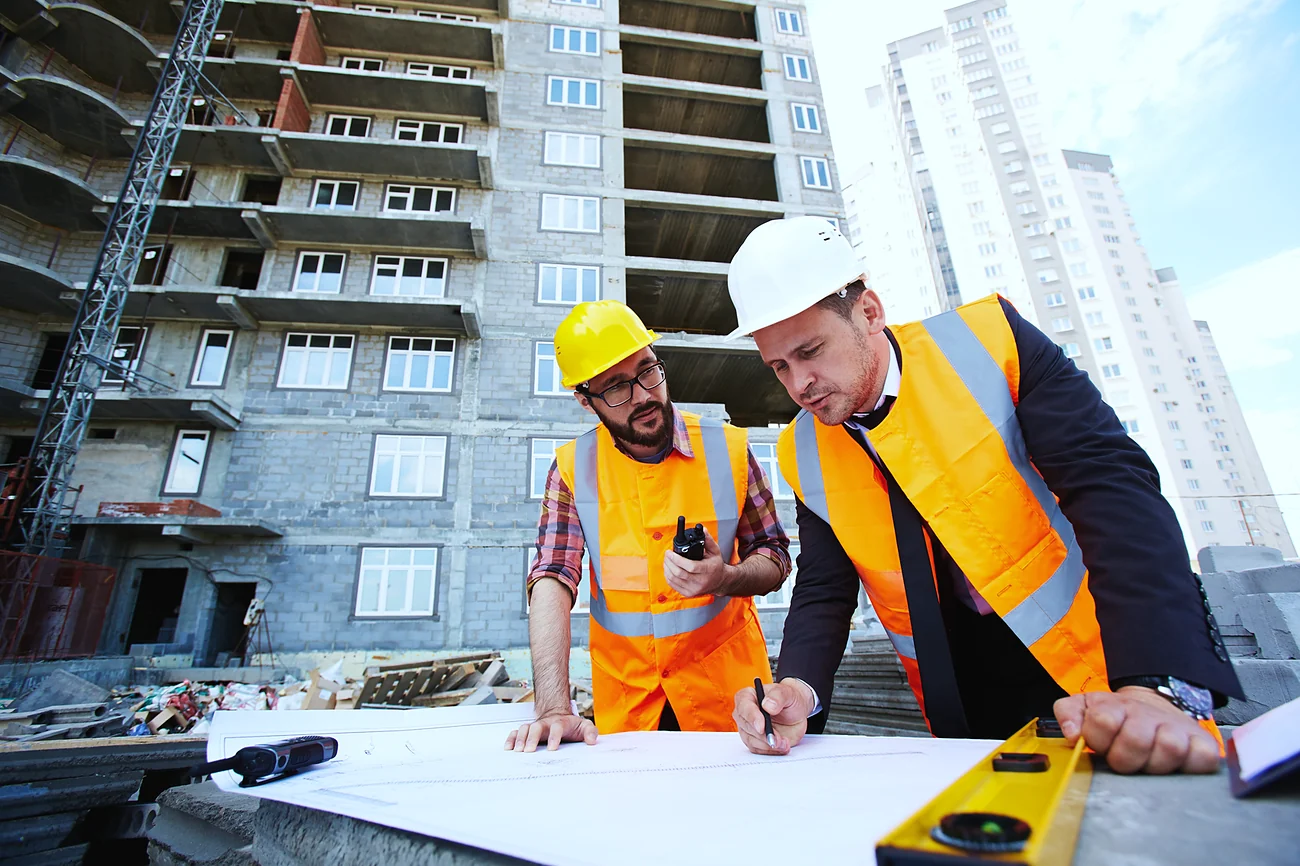 Engenheiros analisando a planta em um canteiro de obras