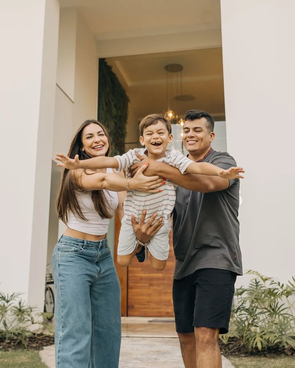Família comemorando em frente à nova casa